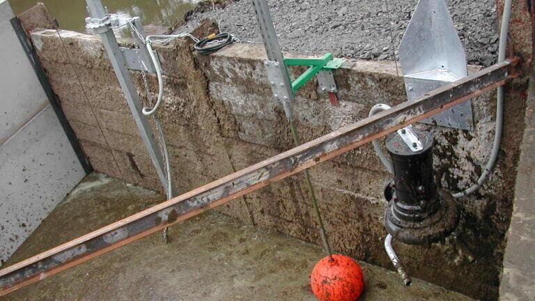 Landia 300 rpm 5.5 kW submersible mixer in the foreground.  Landia 15 kW Long-shaft slurry pump in the background - both in pre-cast reception pit feeding an adjacent gantry-mounted slurry separator.