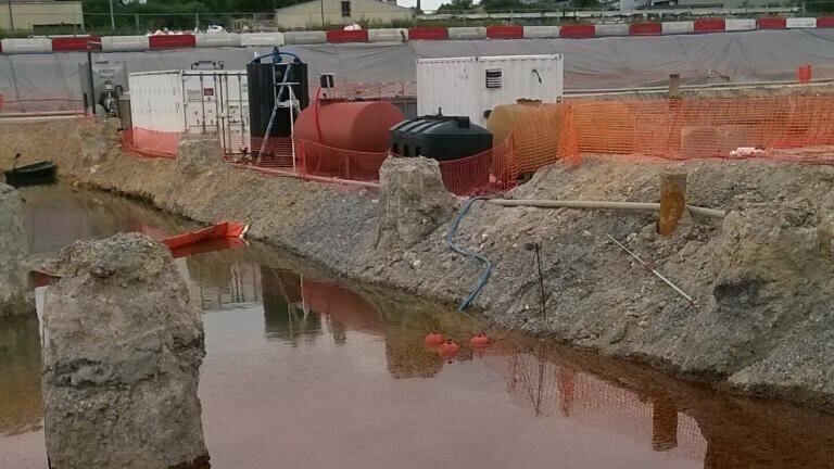 The brownish-red sludge has to go: in the centre of the image, at the edge of the basin, the FSP skimmer with its three red floats, connected via a hose to the mobile waste water treatment system just behind (photo: Tsurumi)